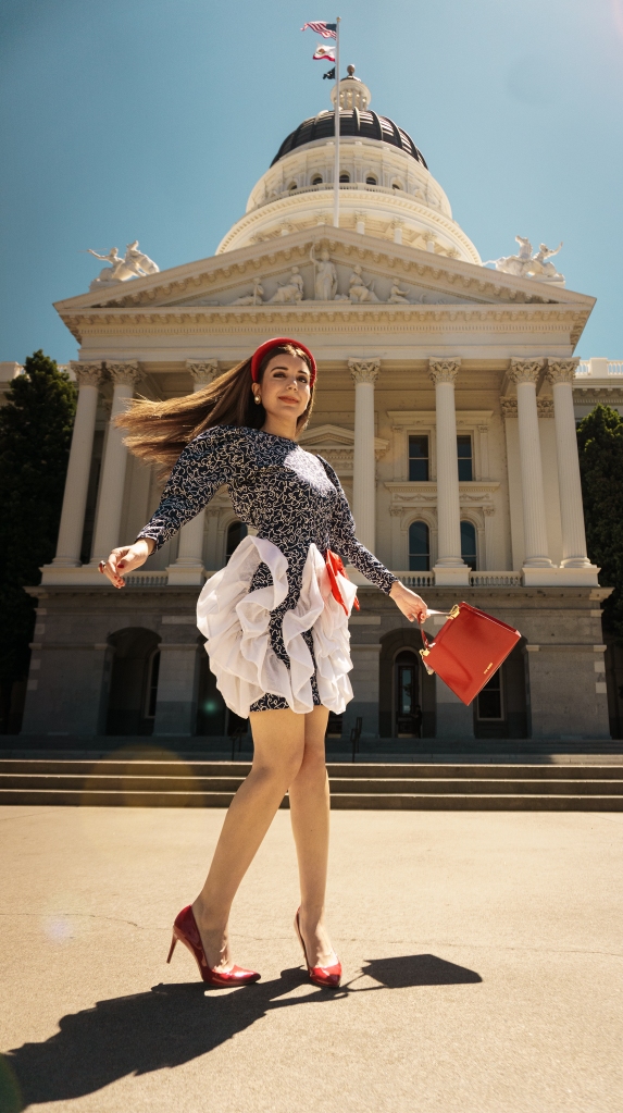 I could not believe that I was walking in such an avant garde gown past a league of legislators and tourists. In cherry-red pumps reminiscent of Dorothy’s ruby slippers, I strutted across the checkered tiles outside the California State Capitol, in place of a yellow brick road. 